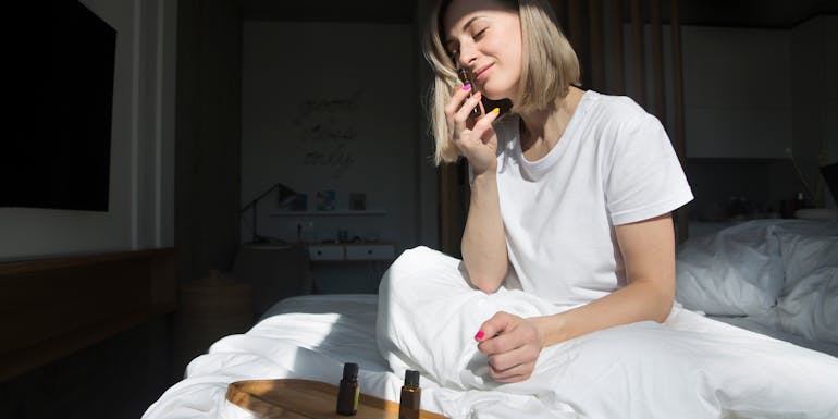 Woman with essential oils in bedroom Woman with essential oils in bedroom