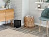 Oskar little humidifier by Stadler Form in black in a bright room next to chair and sideboard