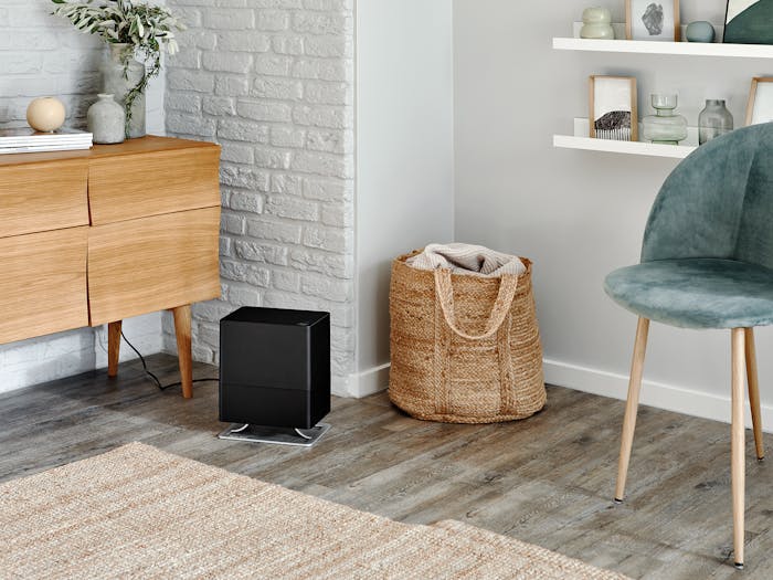 Oskar little humidifier by Stadler Form in black Oskar little humidifier by Stadler Form in black in a bright room next to chair and sideboard