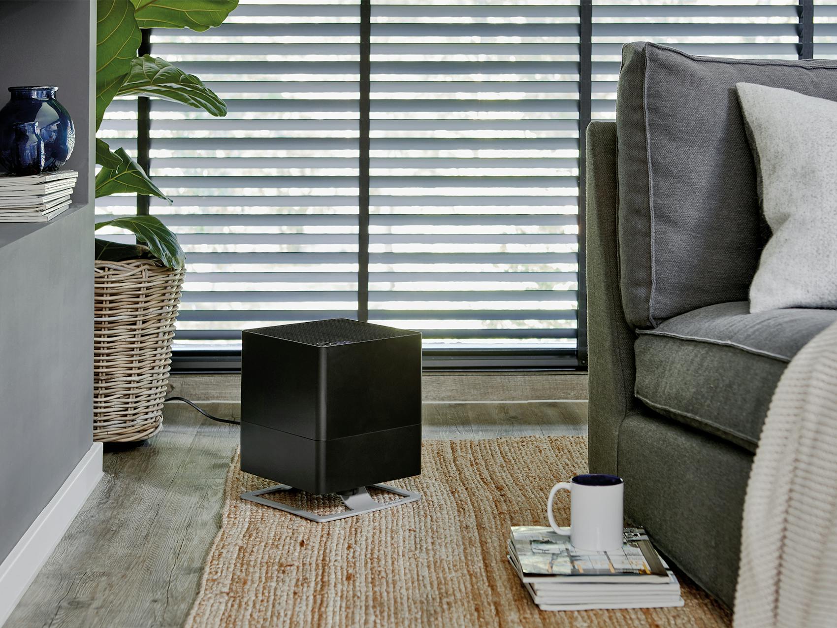 Oskar humidifier by Stadler Form in black next to a couch