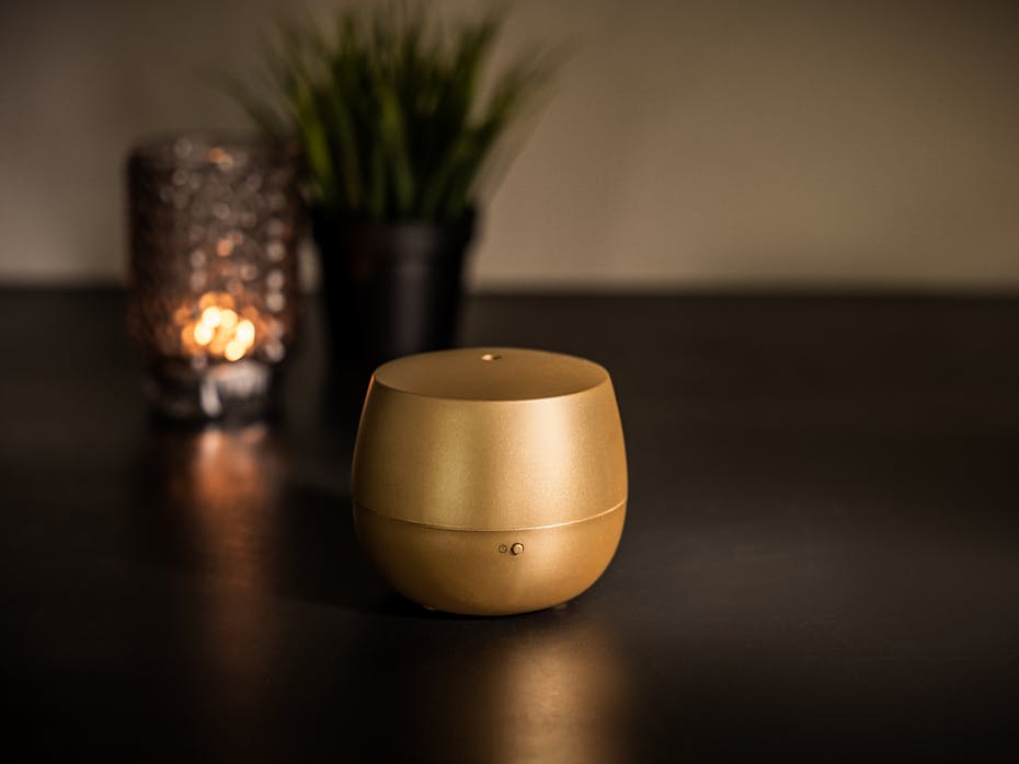 Mia aroma diffuser by Stadler Form in gold on a table