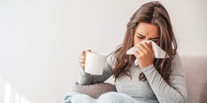 Frau niest mit Tee Woman sneezing with tea