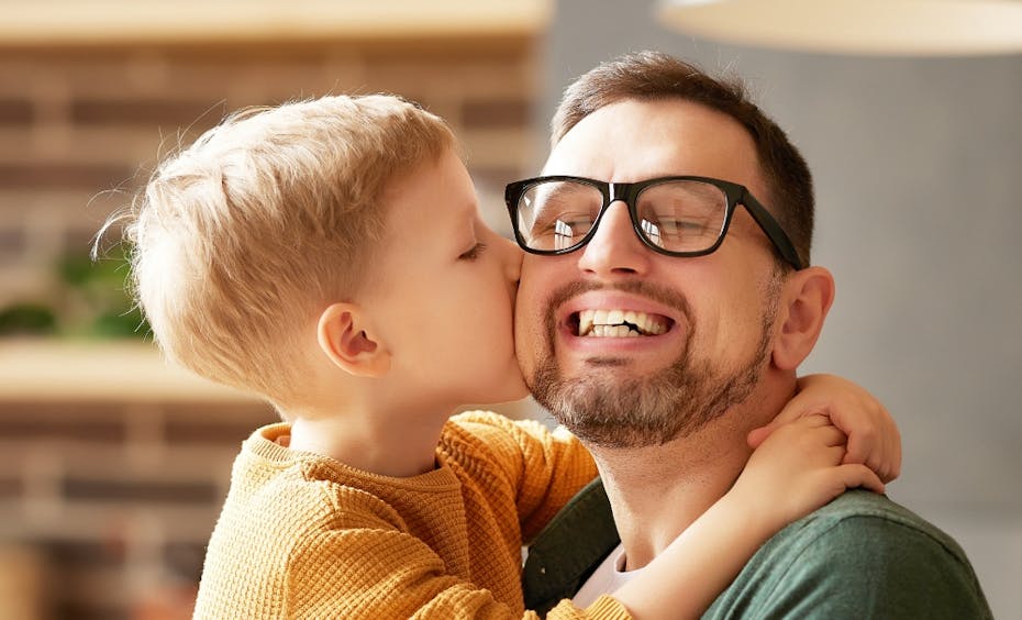 Stadler Form happy faces boy hugs dad Stadler Form happy faces boy hugs father and gives him a kiss on the cheek