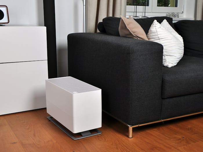 Oskar big humidifier by Stadler Form in white next to a couch