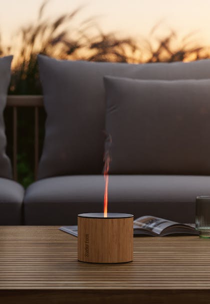 Nora aroma diffuser from Stadler Form on a table in a terrace landscape with evening atmosphere