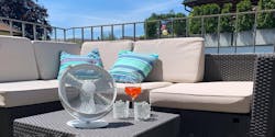 Tim Tischventilator in Weiß von Stadler Form an einem Sommertag auf einem Balkon