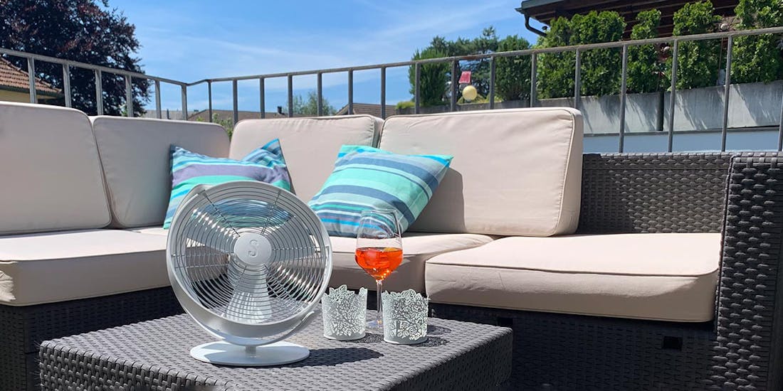 Tim Tischventilator in Weiß von Stadler Form an einem Sommertag auf einem Balkon Tim Tischventilator in Weiß von Stadler Form an einem Sommertag auf einem Balkon