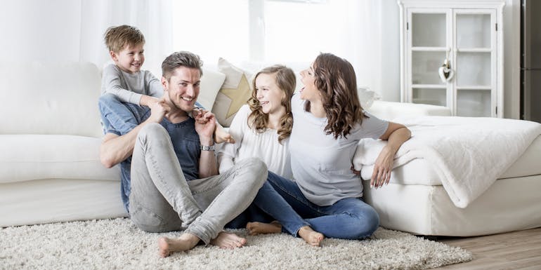 Glückliche Familie auf dem Wohnzimmerboden Glückliche Familie auf dem Wohnzimmerboden