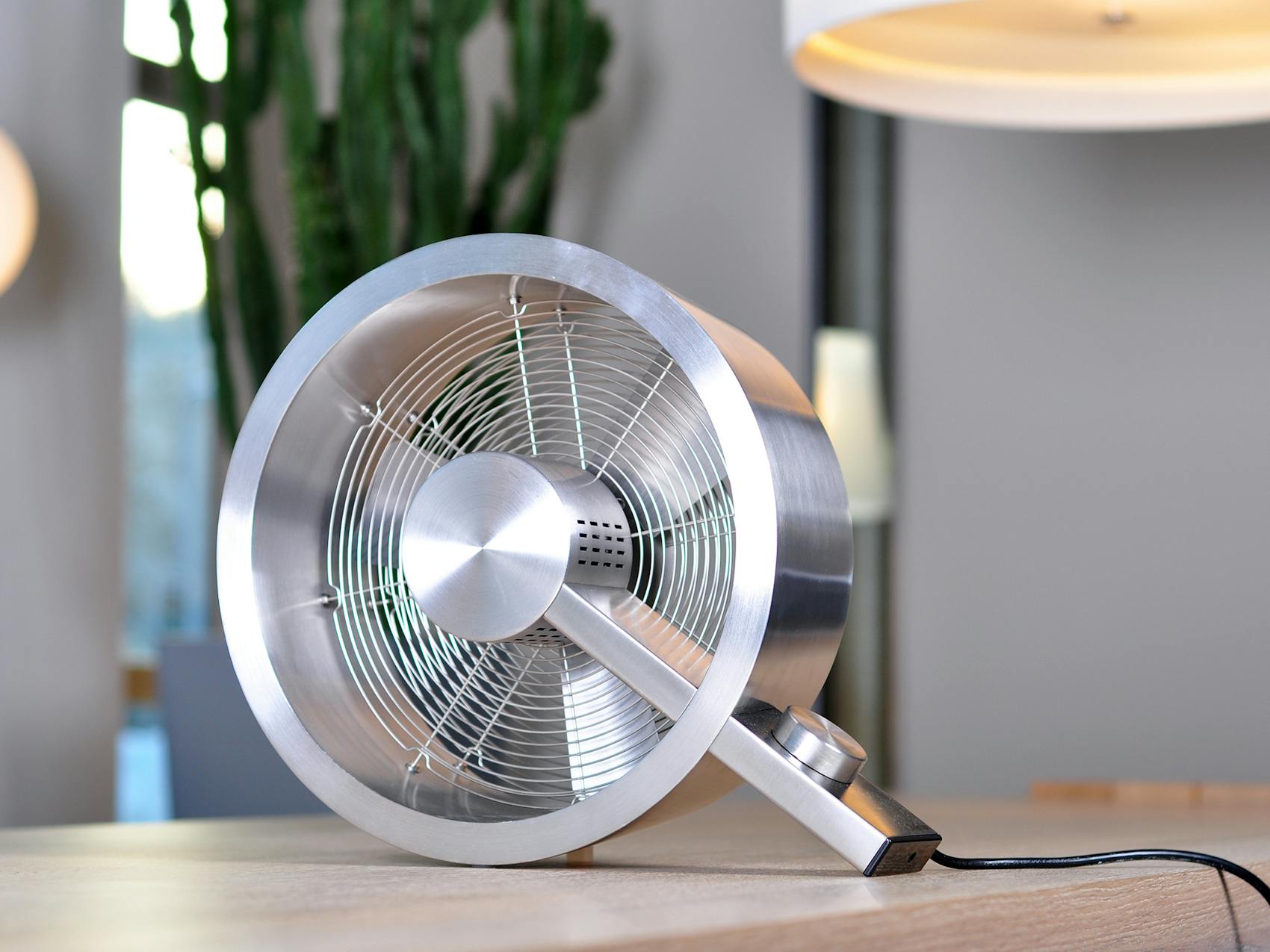 Q design fan by Stadler Form on a table