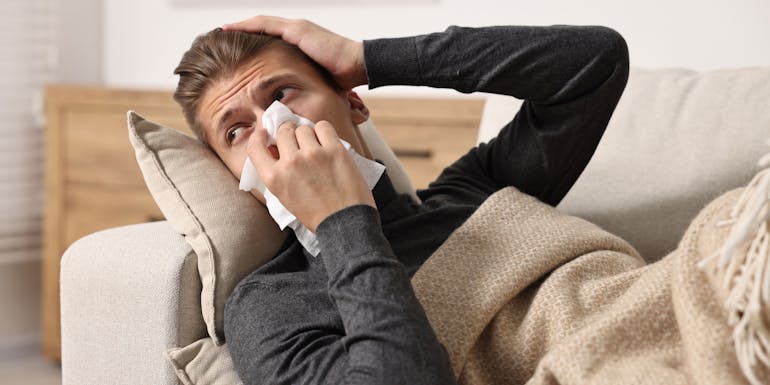 Man niest auf dem Sofa. Man niest auf dem Sofa