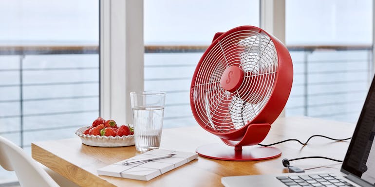Tim table fan by Stadler Form in chili red next to a laptop Tim table fan by Stadler Form in chili red next to a laptop