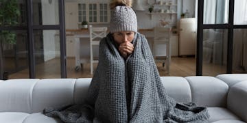 Frau friert in Wohnung