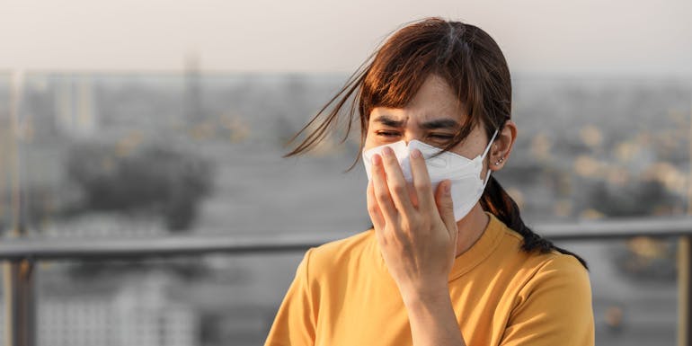 Woman with mask in a polluted city Woman with mask in a polluted city