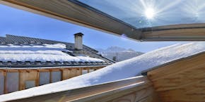 Open roof window in winter with snow