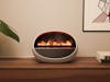 Erik fan heater with flame effect by Stadler Form on a sideboard