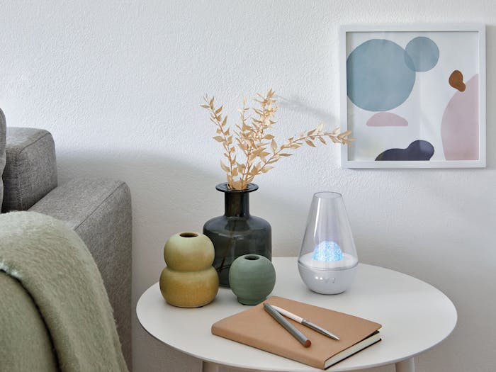 Nina aroma diffuser by Stadler Form with fragrance globe Blue Rosewood on a couch table
