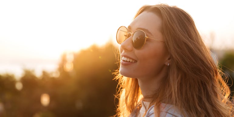 Frau mit Sonnenbrille im Sonnenuntergang Frau mit Sonnenbrille im Sonnenuntergang