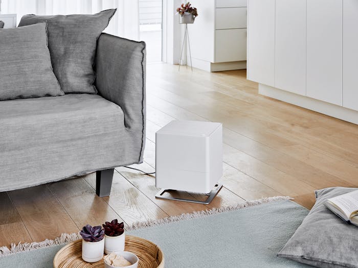 Oskar humidifier by Stadler Form in white on the floor next to a couch