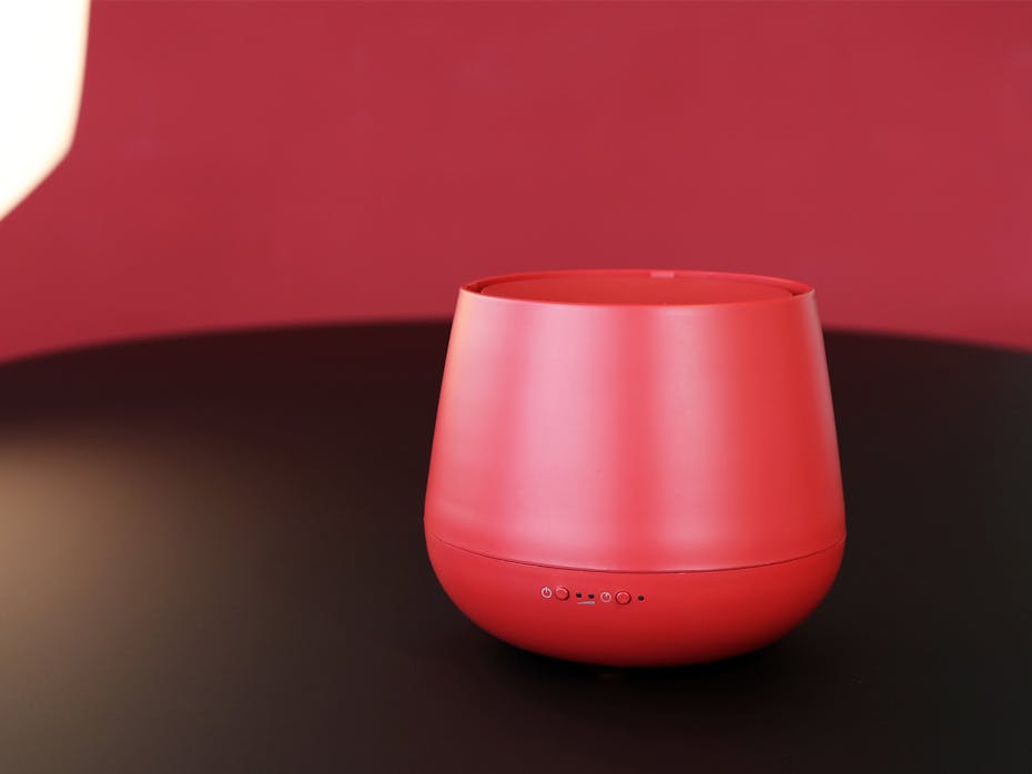 Julia aroma diffuser by Stadler Form in chili red on a wood table