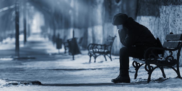 Person with winter blues on a bench Person mit Winterblues auf einer Bank