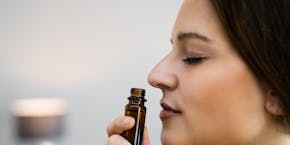 Woman inhales essential oil Woman inhales essential oil