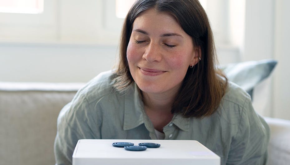 Woman smelling on fragrance pin blue rosewood