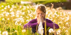 Fille avec allergie assise dans un pré fleuri
