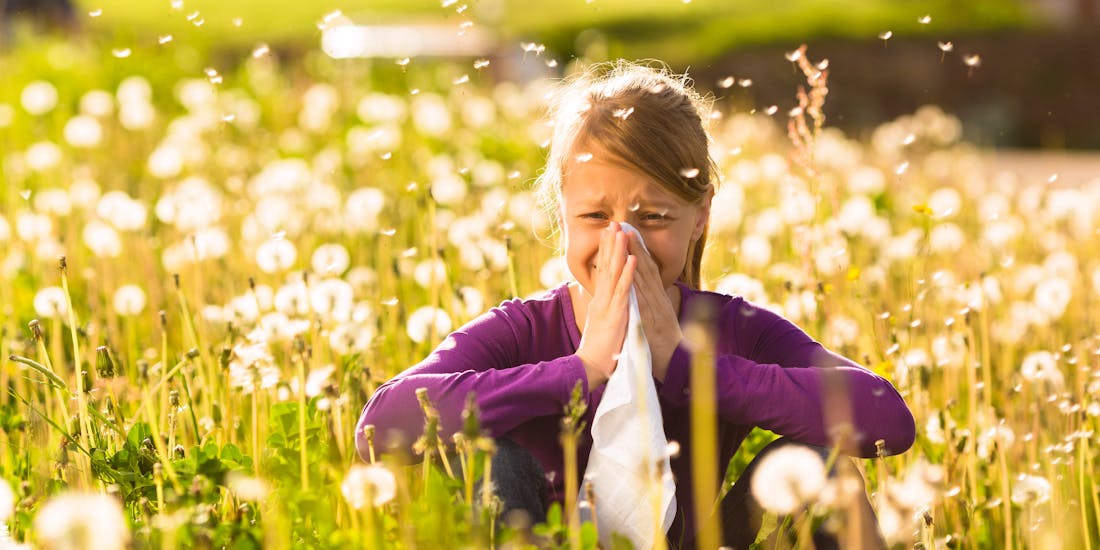 Mädchen mit Allergie sitzt in einer Blumenwiese Mädchen mit Allergie sitzt in einer Blumenwiese