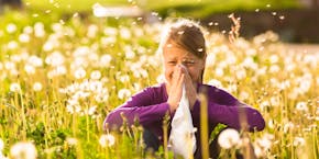 Girl with allergy sits in a flower meadow Girl with allergy sits in a flower meadow