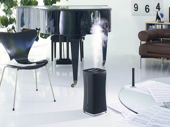 Eva humidifier by Stadler Form in black next to a grand piano
