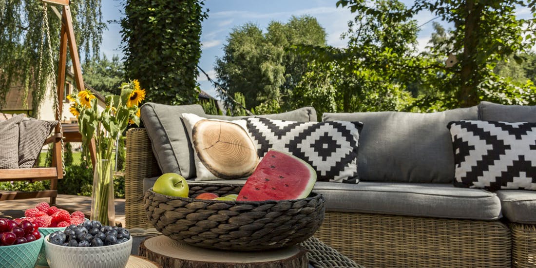 Sitzbereich im Sommer auf dem Balkon mit Obst auf dem Tisch Sommersitzbereich auf dem Balkon mit Obst auf dem Tisch
