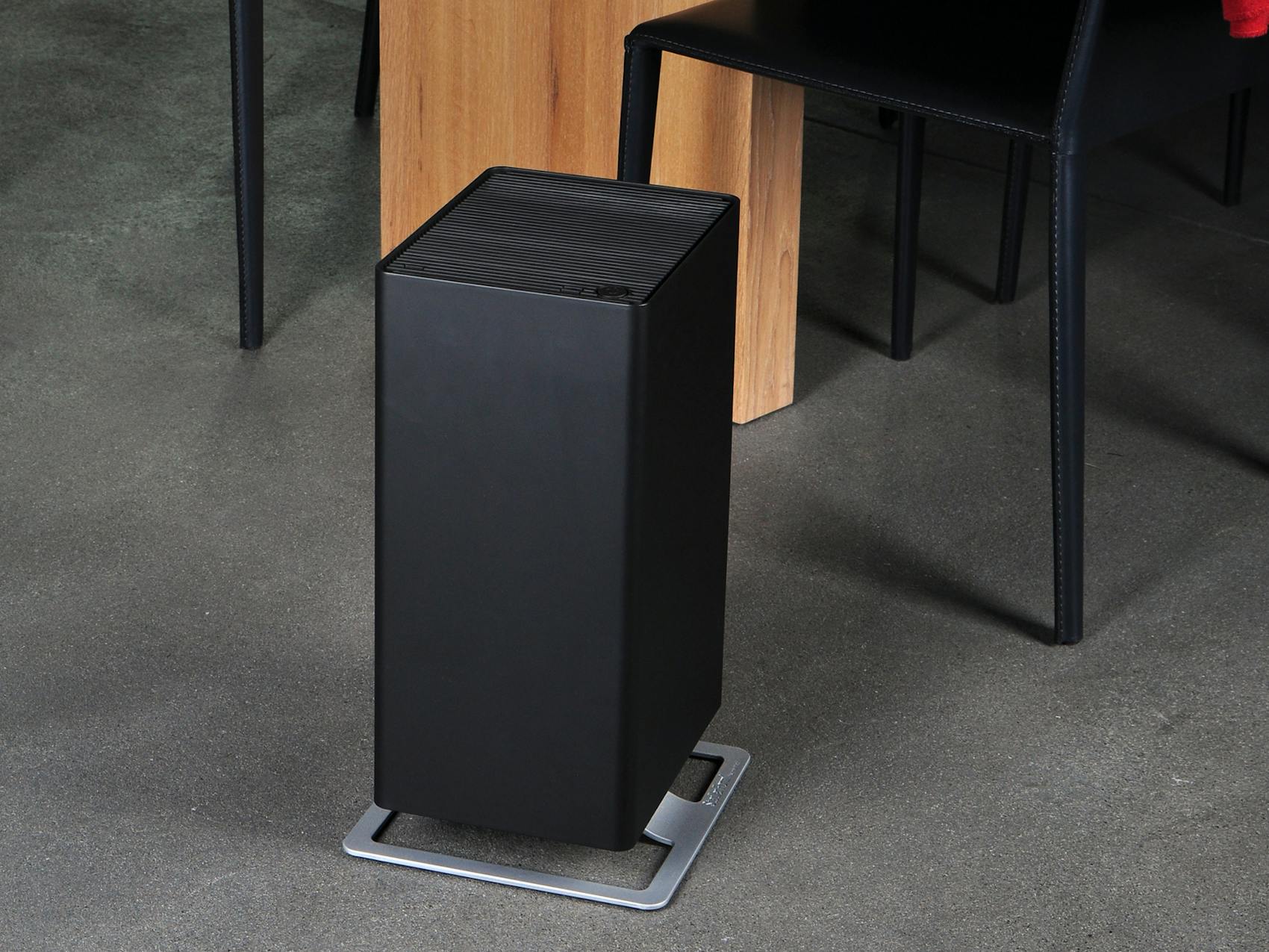 Viktor air purifier by Stadler Form in black next to a dining table
