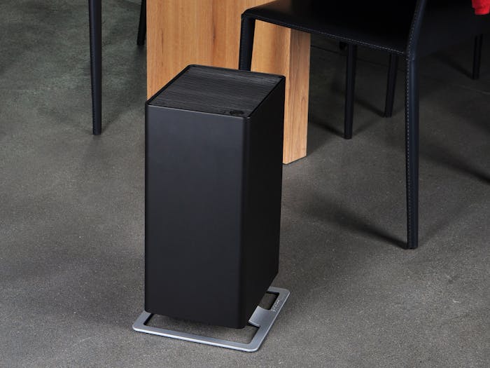 Viktor air purifier by Stadler Form in black next to a dining table