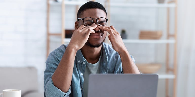 Man im Homeoffice reibt sich die Augen Man im Homeoffice reibt sich die Augen