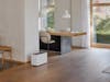 Noah Pro humidifier by Stadler Form in a large, open living area between the coat rack, dining table, and seating area.