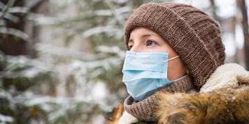 Frau im Winter draußen mit Gesichtsmaske