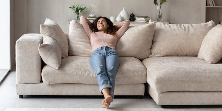 Frau entspannt sich auf einem Sofa Frau entspannt sich auf einem Sofa
