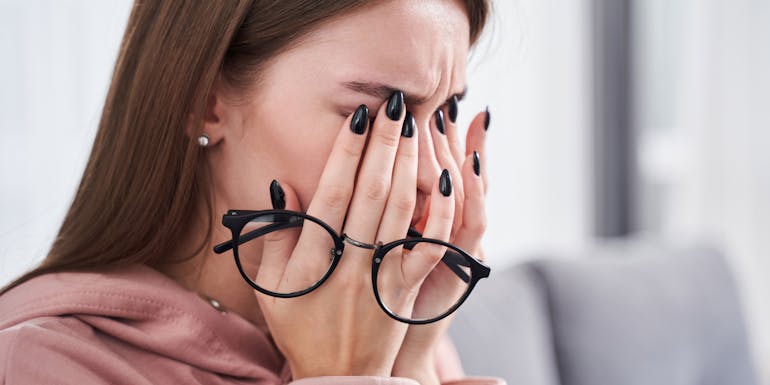 Woman rubs her eyes Woman rubs her eyes