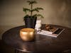 Jasmin aroma diffuser by Stadler Form in gold on a table