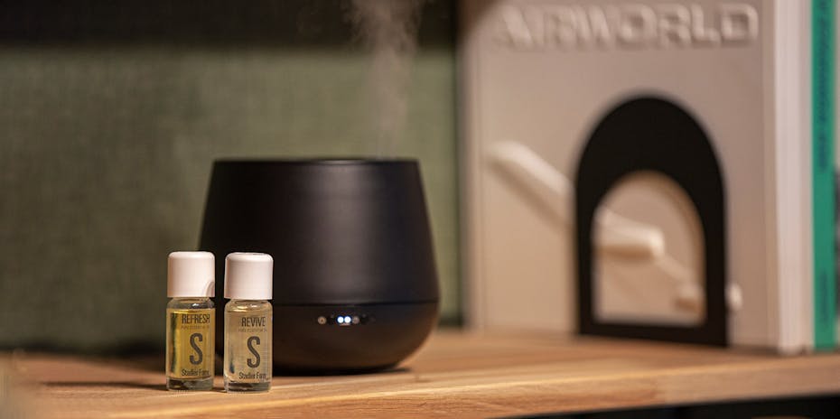 Close-up Julia aroma diffuser in black with essential oils by Stadler Form on a book shelf