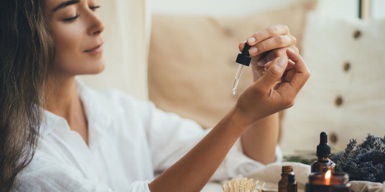Eine Frau verwendet Aroma Öl auf der Haut Eine Frau verwendet Aroma Öl auf der Haut
