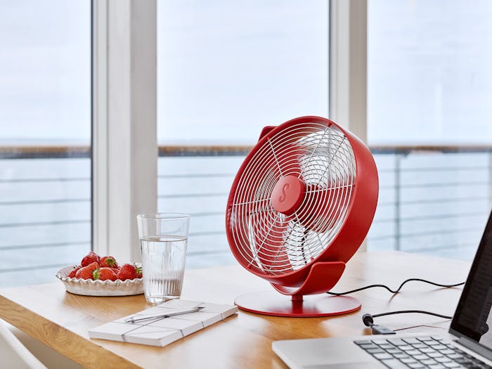 Tim table fan by Stadler Form in chili red on a homeoffice desk