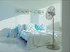 Charly stand fan by Stadler Form in a bedroom
