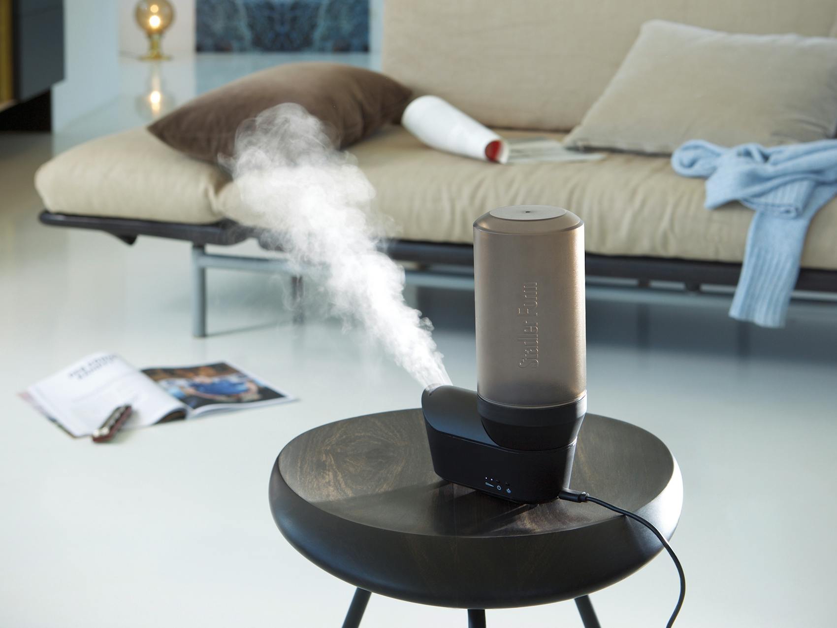 Emma personal humidifier by Stadler Form in black on a coffee table