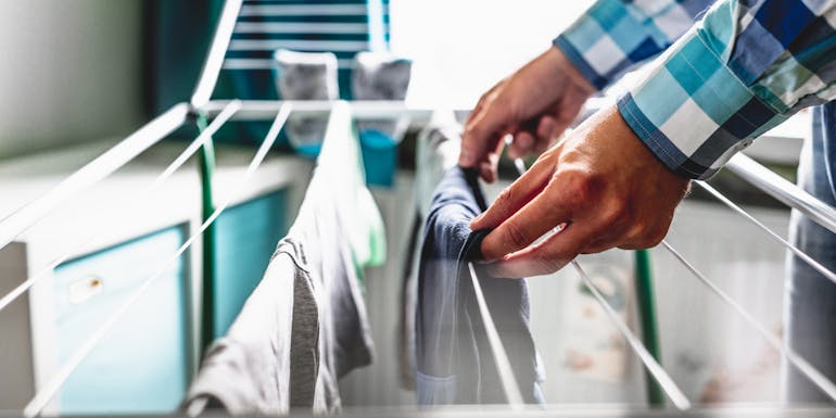 Un homme étend le linge Un homme étend le linge