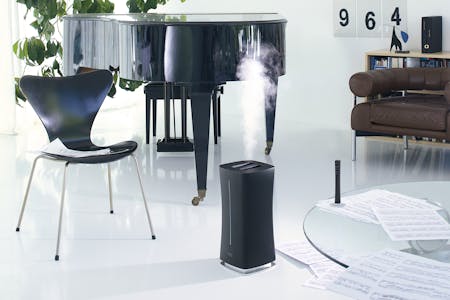 Eva Luftbefeuchter von Stadler Form in Schwarz in einem Wohnzimmer Eva Luftbefeuchter von Stadler Form in Schwarz in einem Wohnzimmer mit einem Klavier