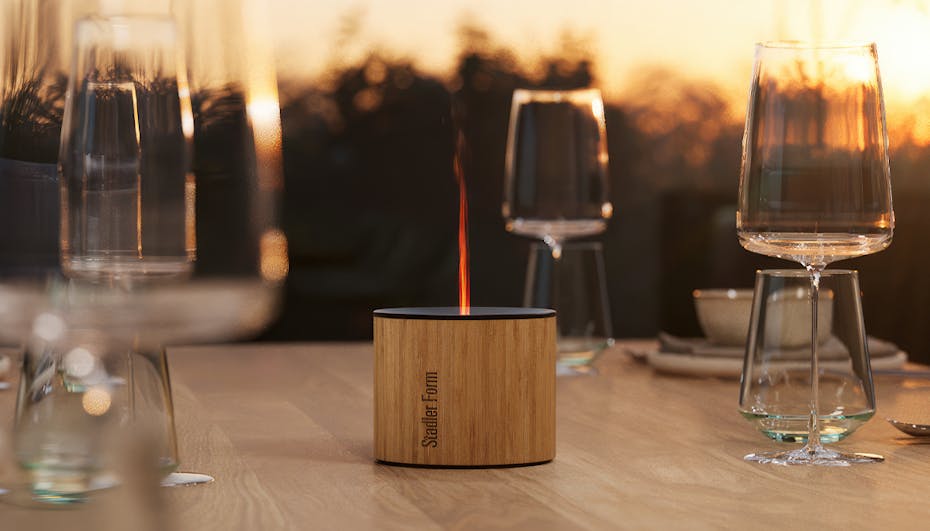 Nora aroma diffuser from Stadler Form on a dining table outside Nora aroma diffuser from Stadler Form on a dining table outside