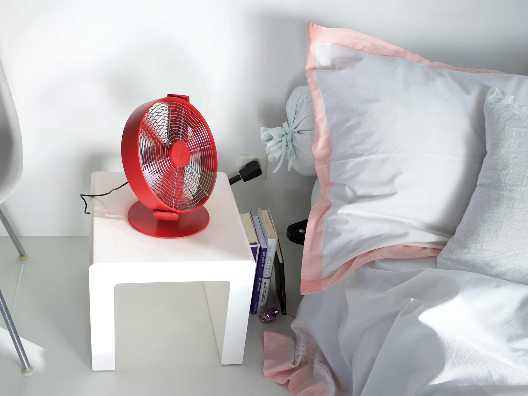 Tim table fan by Stadler Form in chili red in a bedroom