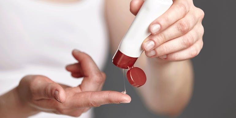 Woman applies moisturizer Frau trägt Feuchtigkeitscreme auf