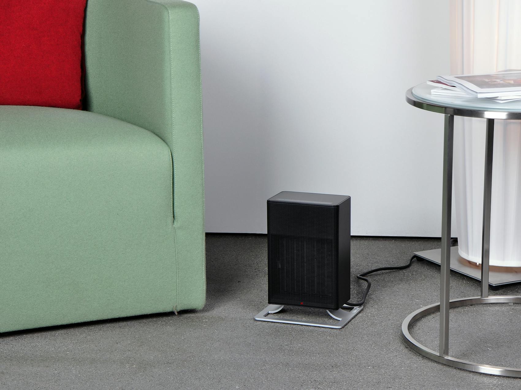 Anna little heater by Stadler Form in black in a living room